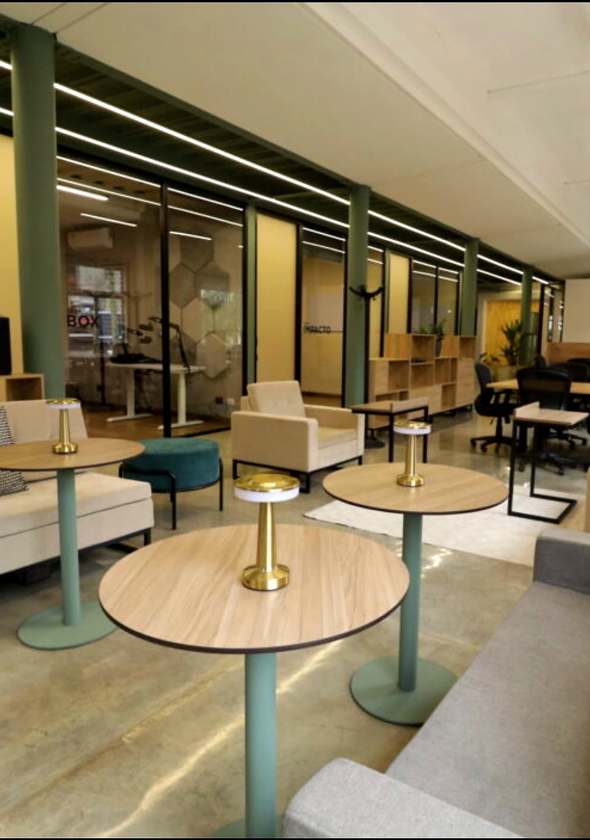 Interior del área común de Randa Studio en Granada, Cali: espacio de coworking con lounge, mesas y salas de reuniones al fondo