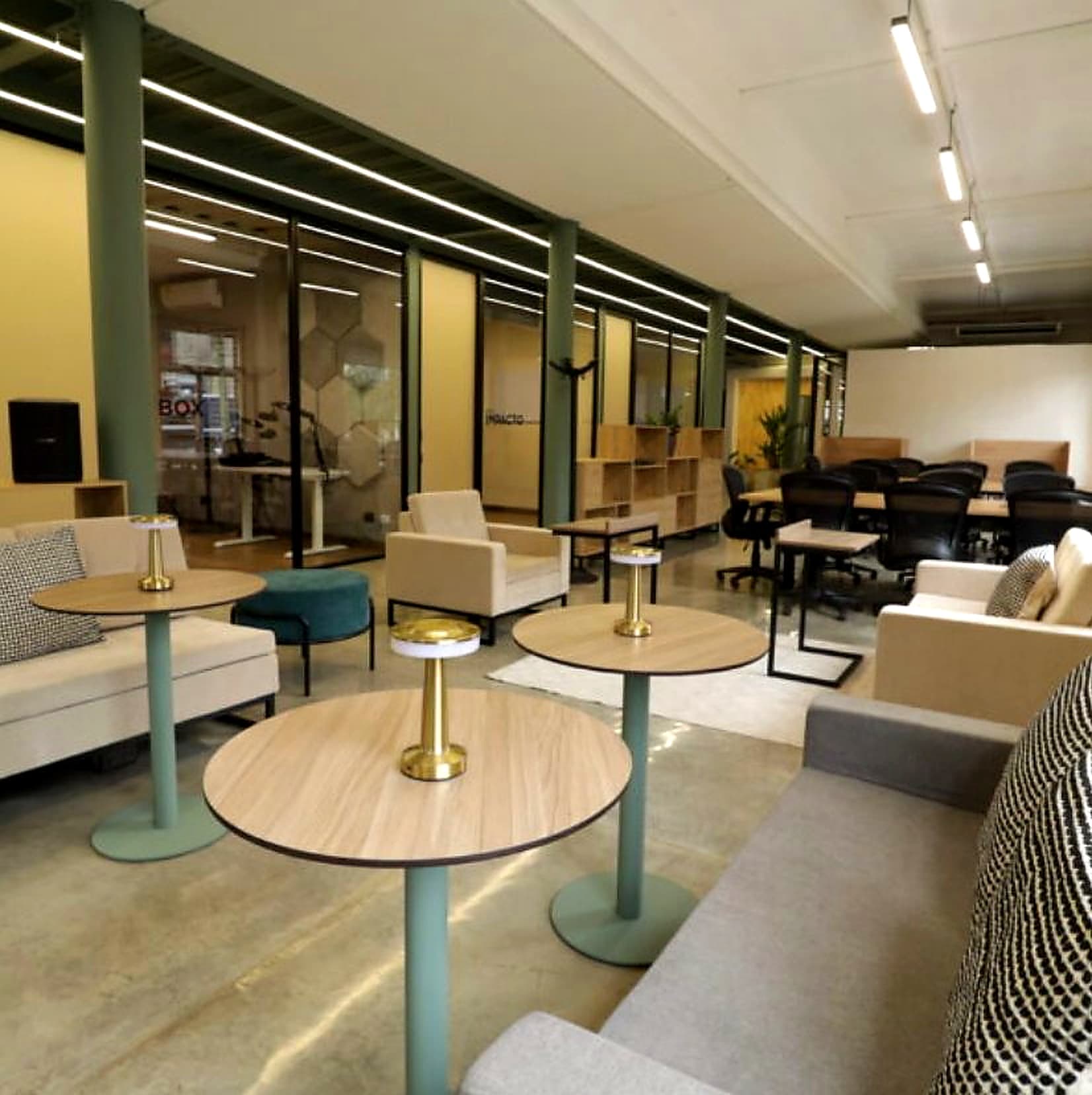 Interior de Randa Studio: área común de coworking con escritorios, lounge y salas de reuniones con vidrio